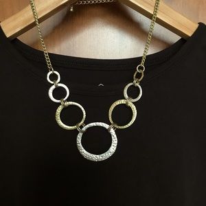Open circle necklace with hammered texture. Gold and silver toned